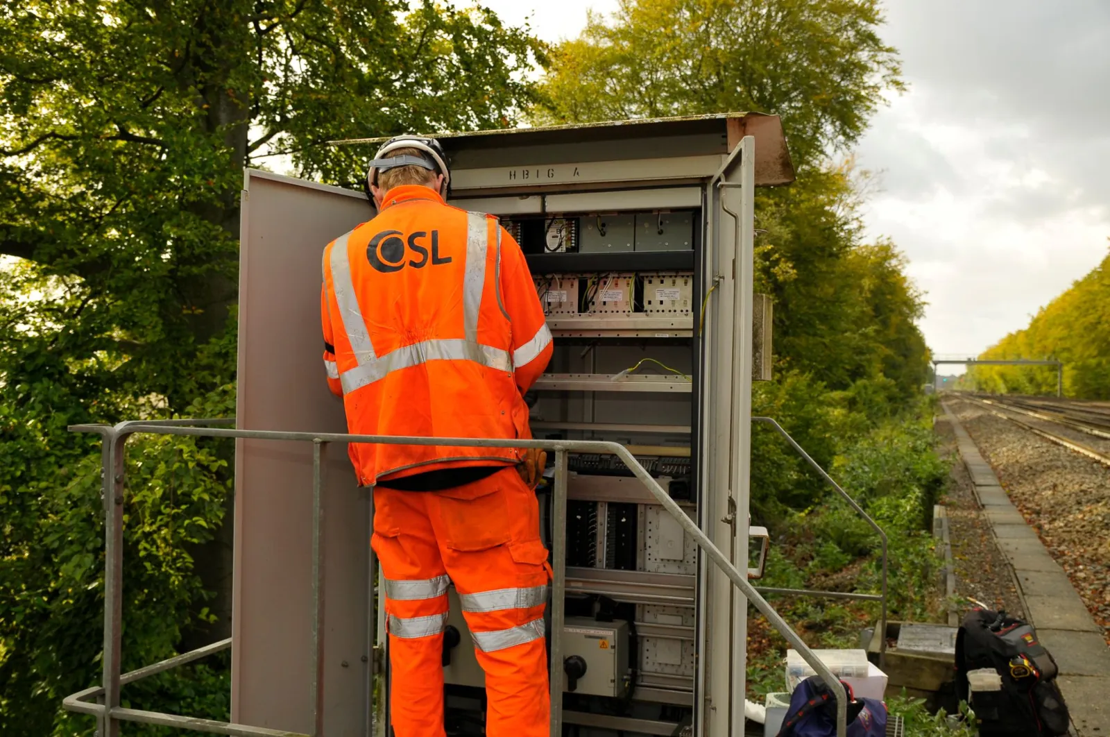 OSL engineer working in an open lineside location cabinet beside the track